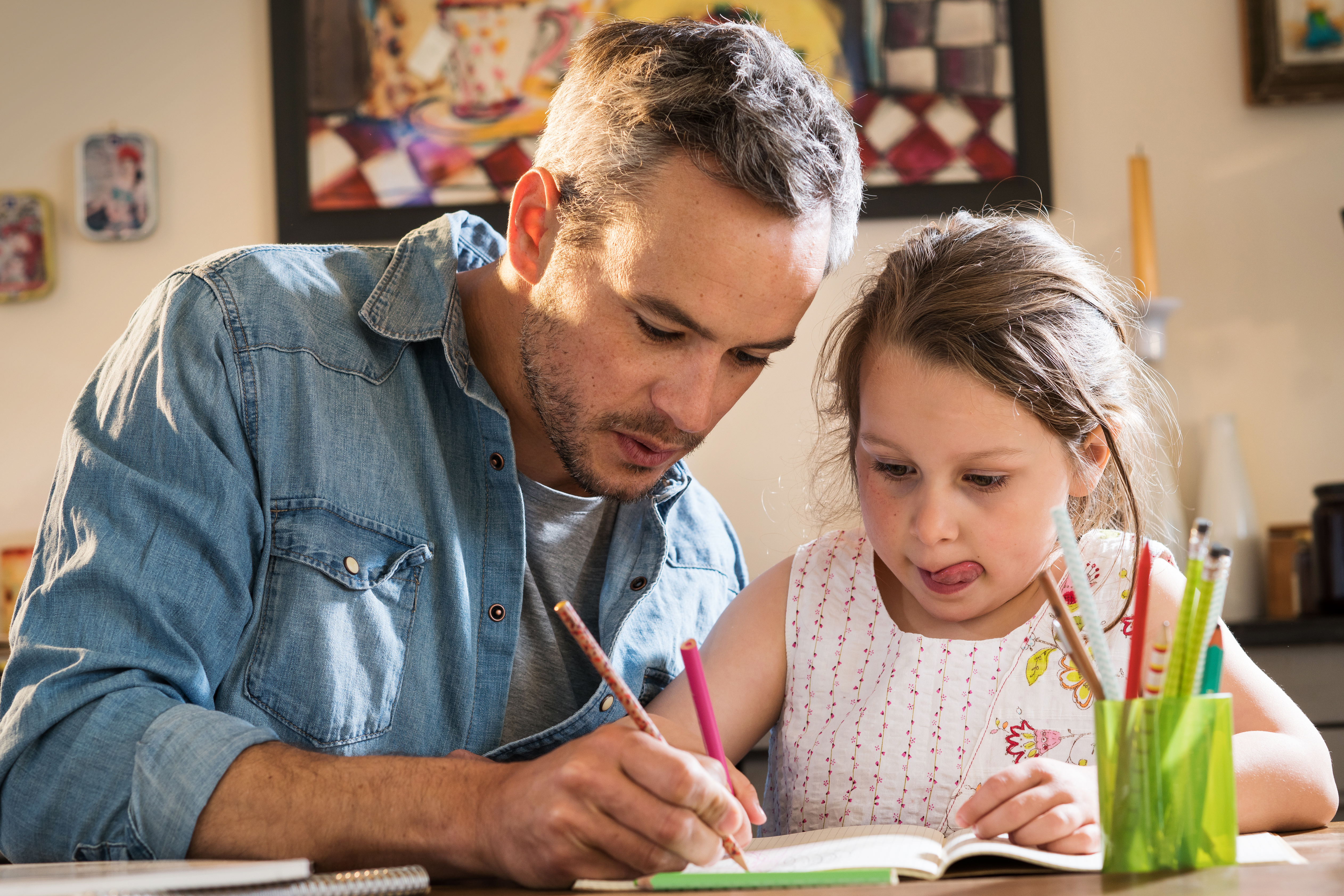 father and child working on homework together